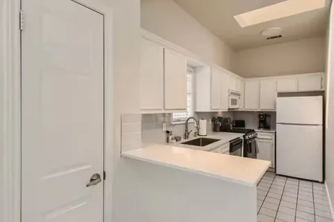 a kitchen with a refrigerator a sink and cabinets