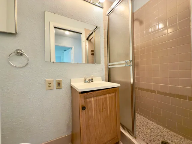 a bathroom with a granite countertop sink and a mirror