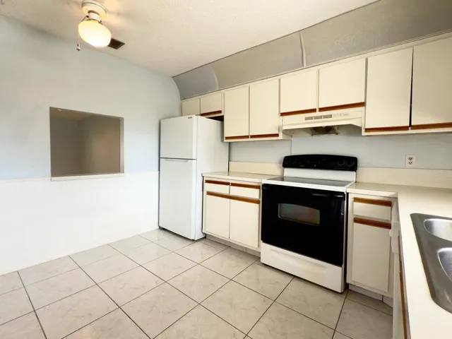 a kitchen with cabinets stainless steel appliances and wooden floor
