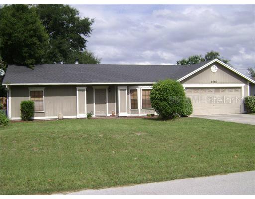 1583 Dublin Road Deltona, FL 32738 - Photo 1 of 1 a front view of a house with a garden