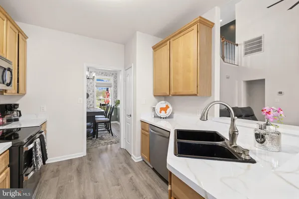 a kitchen with stainless steel appliances granite countertop white cabinets and a stove top oven