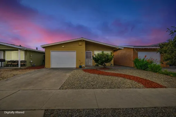 a front view of a house with a yard and a garage