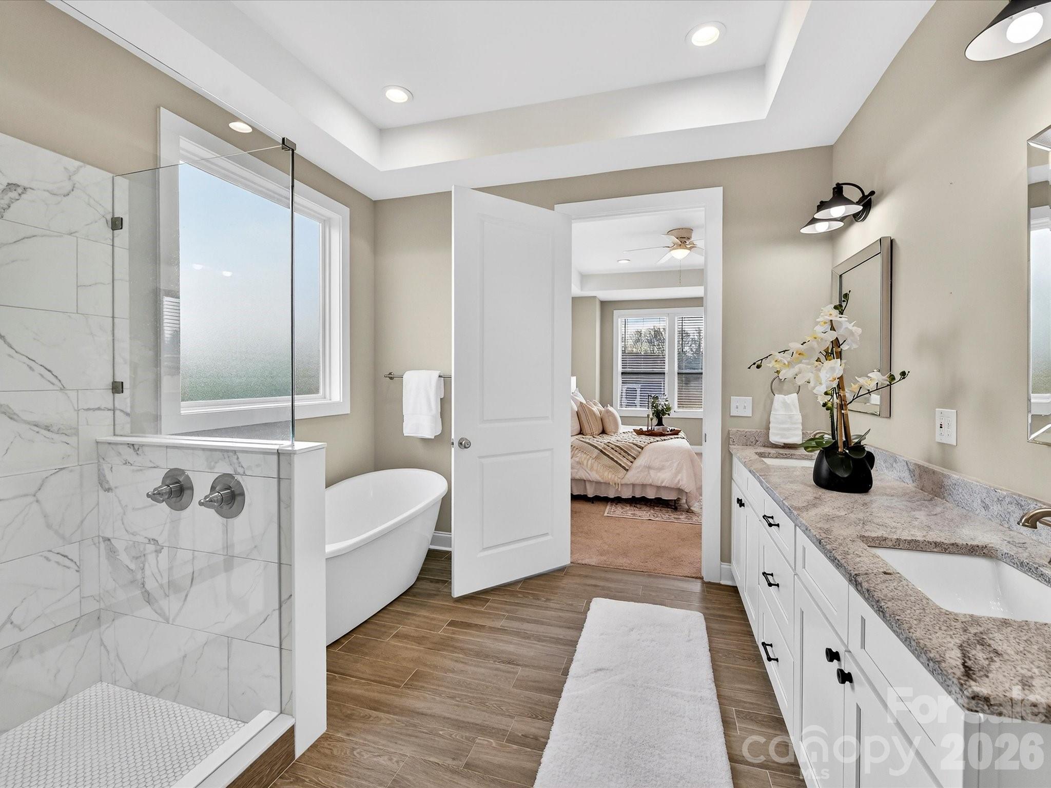 215 Lone Pine Road Statesville, NC 28625 - Photo 15 of 30 a spacious en suite bathroom with a granite countertop double vanity sink a mirror and a bathtub