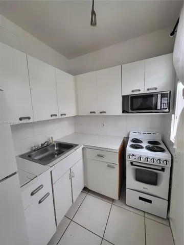 a kitchen with a stove sink and cabinets