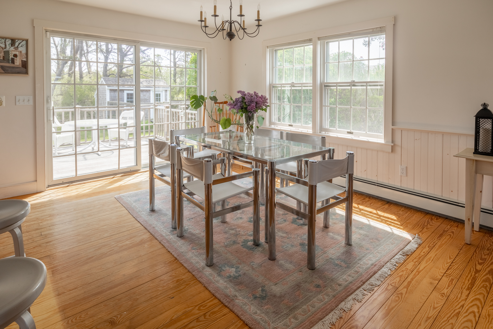 15 Swift Rock Road Nantucket, MA 02554 - Photo 11 of 32 a dining room with wooden floor a chandelier a glass table and chairs