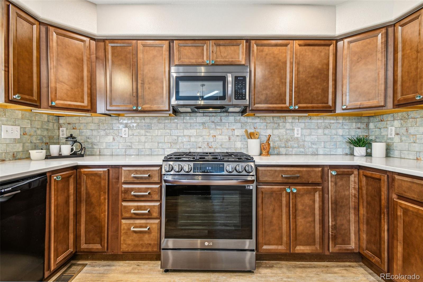 9722 Kipling Street Westminster, CO 80021 - Photo 16 of 45 a kitchen with granite countertop a stove top oven microwave and cabinets