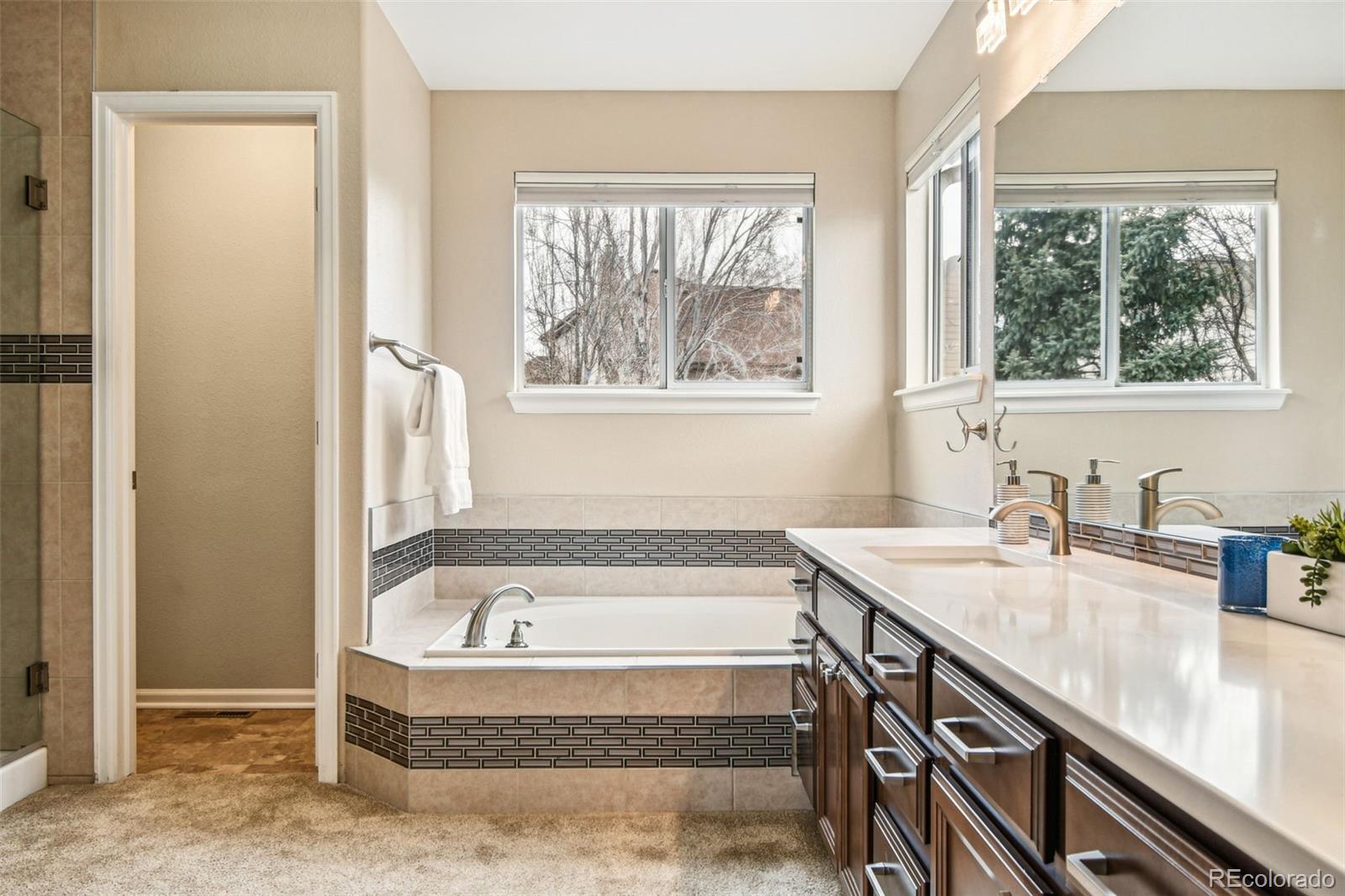 9722 Kipling Street Westminster, CO 80021 - Photo 22 of 45 a bathroom with a granite countertop tub and a sink