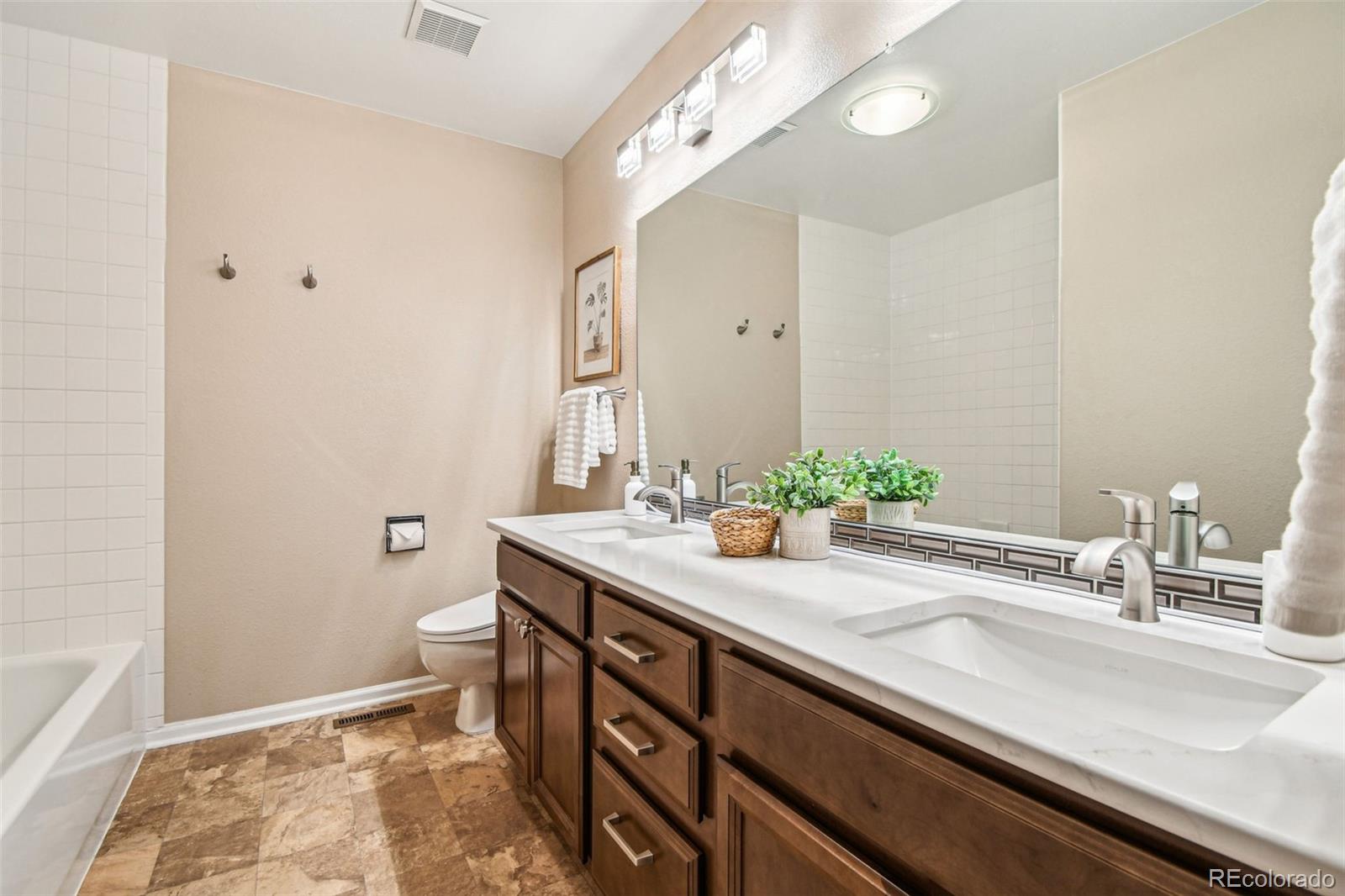 9722 Kipling Street Westminster, CO 80021 - Photo 30 of 45 a bathroom with a sink a toilet and a mirror