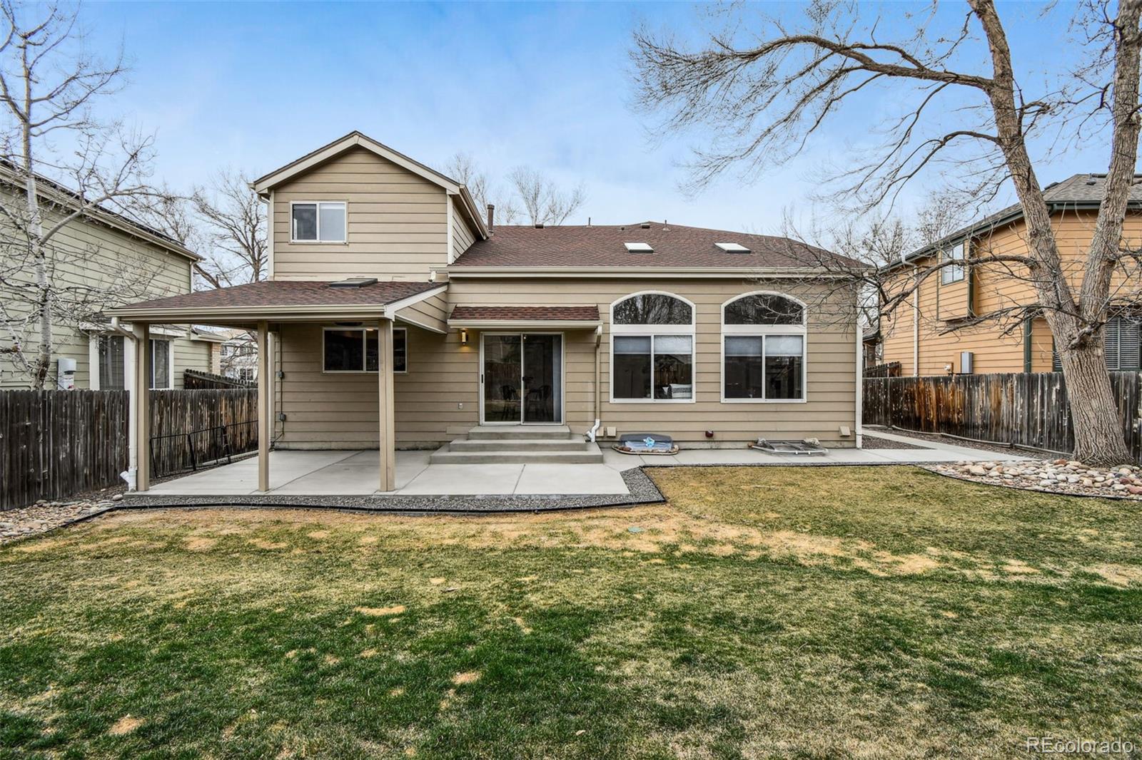 9722 Kipling Street Westminster, CO 80021 - Photo 41 of 45 a view of a white house with a large pool and lawn chairs under an umbrella