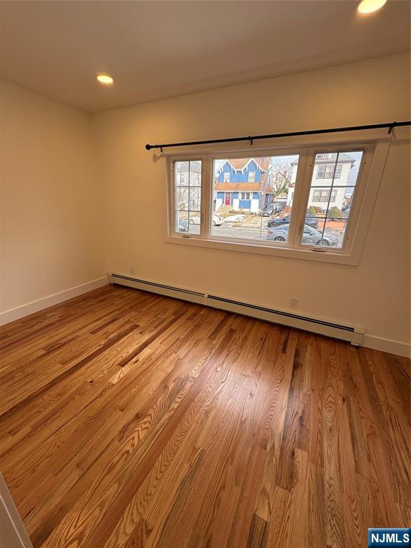 904 Kilsyth Road, Unit 1 Elizabeth, NJ 07208 - Photo 15 of 17 a view of an empty room with wooden floor and a window