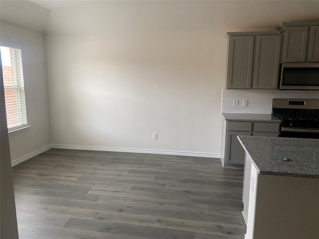 2116 Camellia Street Princeton, TX 75407 - Photo 5 of 5 Unfurnished dining area with dark wood-type flooring and baseboards