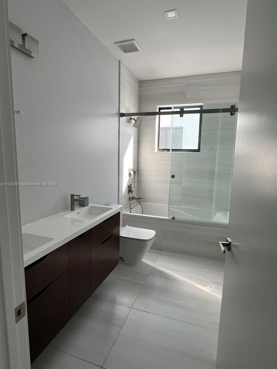 1531 Southwest 22nd Terrace Miami, FL 33145 - Photo 19 of 29 a bathroom with a double vanity sink toilet mirror and shower
