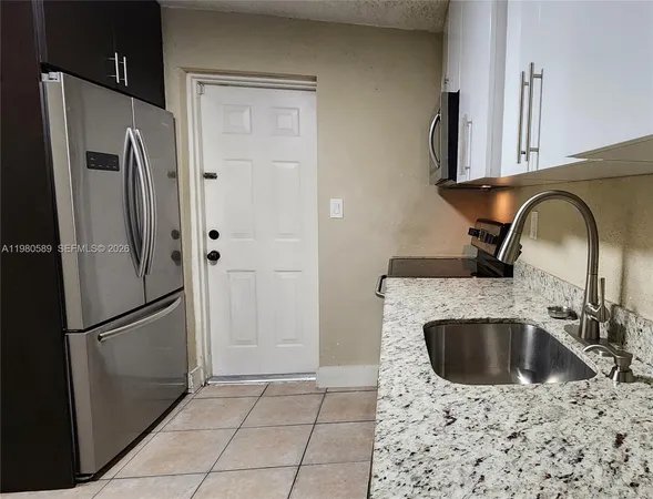 a kitchen with stainless steel appliances a refrigerator a sink a stove and cabinets
