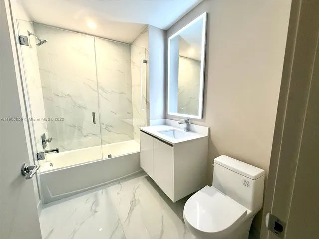 a bathroom with a granite countertop toilet sink and bathtub