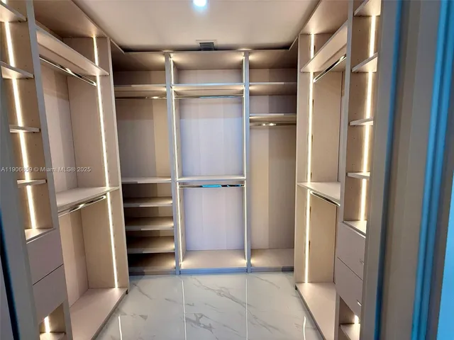 a view of walk in closet with empty racks