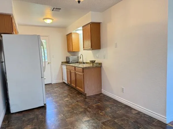 a view of a kitchen with a sink and a refrigerator