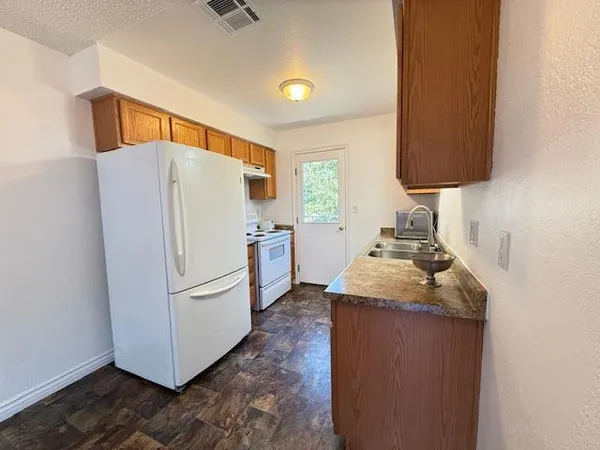 a view of a kitchen with a sink and a refrigerator