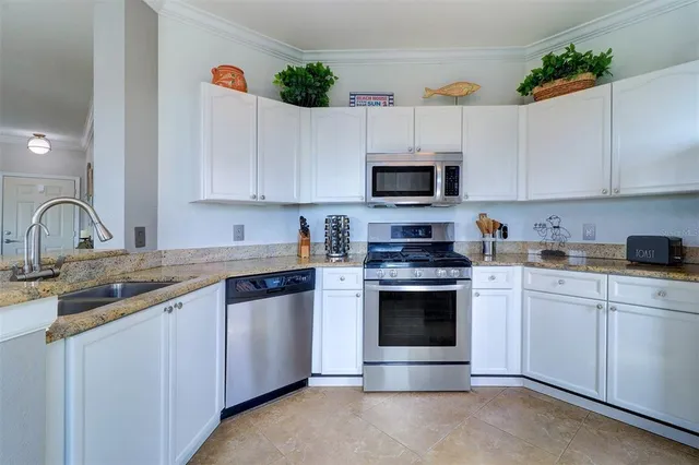 a kitchen with cabinets stainless steel appliances and a sink