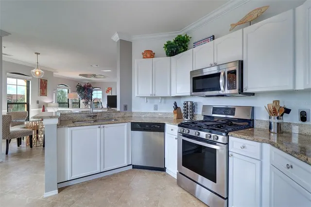 a kitchen with granite countertop a stove top oven microwave and cabinets