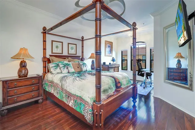 a bedroom with a bed mirror and painting on the wall