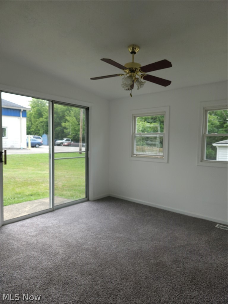 4660 Darrow Road Stow, OH 44224 - Photo 10 of 25 Bright family room with neutral carpet flooring, ceiling fan with brass accents, multiple windows and sliders to patio