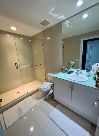 a bathroom with a double vanity sink toilet and shower
