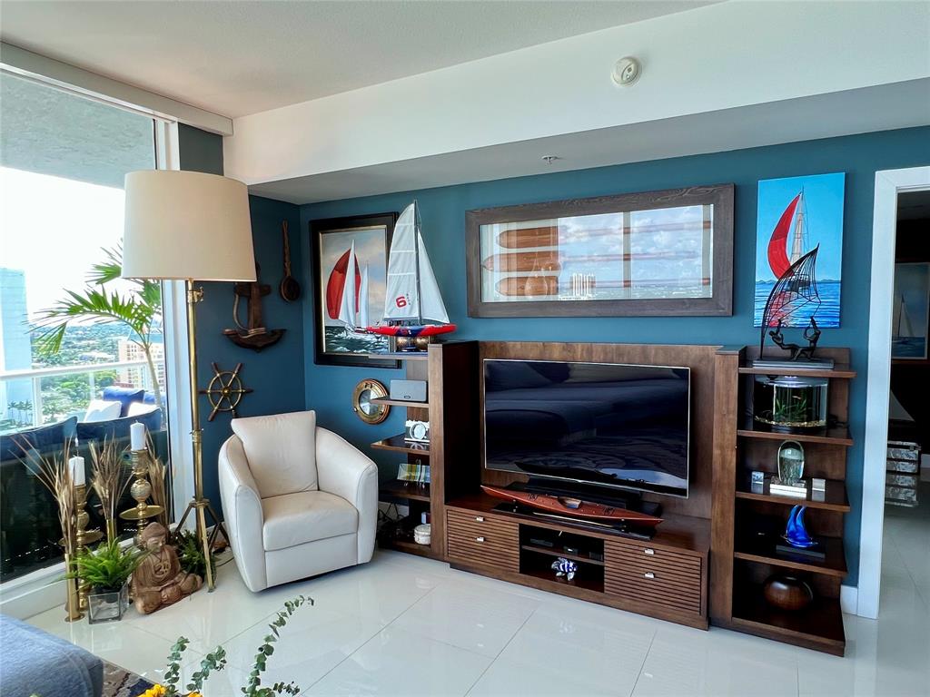 315 Northeast 3rd Avenue, Unit 2107 Fort Lauderdale, FL 33301 - Photo 7 of 19 a living room with furniture a flat screen tv and a fireplace