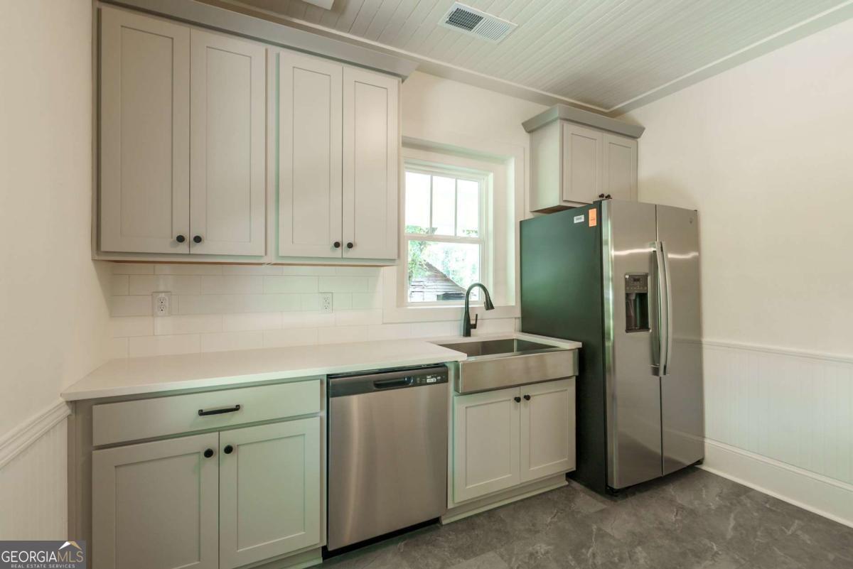 5380 Guthrie Road Loganville, GA 30052 - Photo 16 of 38 a kitchen with a sink and refrigerator