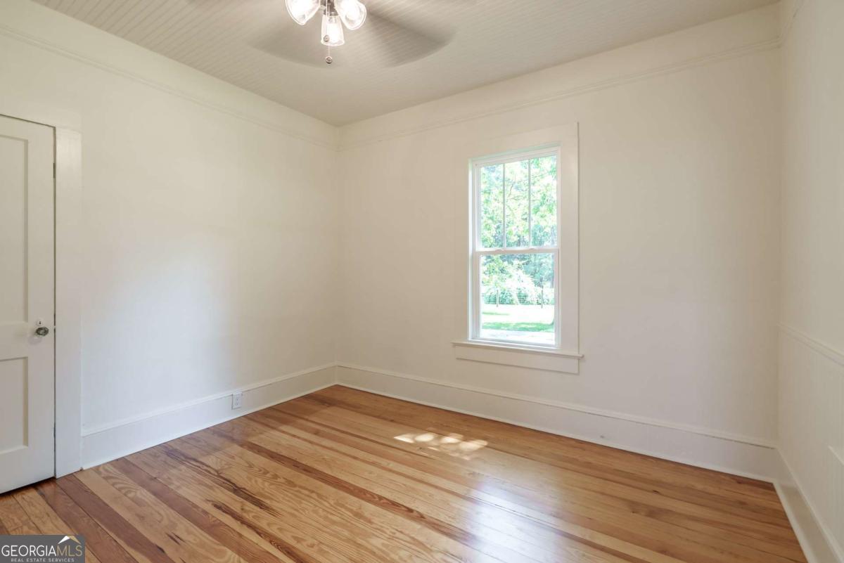 5380 Guthrie Road Loganville, GA 30052 - Photo 23 of 38 a view of empty room with wooden floor and fan