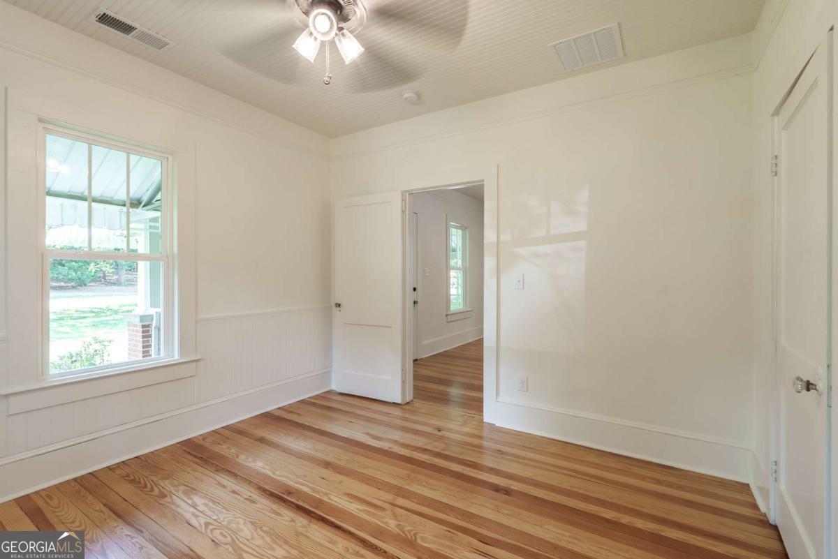 5380 Guthrie Road Loganville, GA 30052 - Photo 25 of 38 a view of an empty room with wooden floor and a window