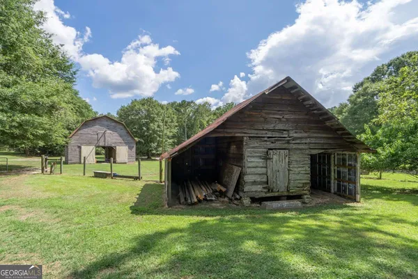 a backyard of a house with wooden fence and large trees