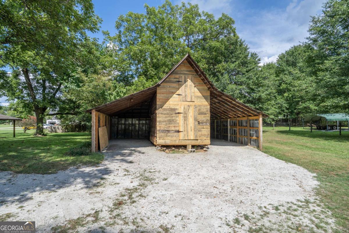 5380 Guthrie Road Loganville, GA 30052 - Photo 30 of 38 a backyard of a house with wooden fence and large trees