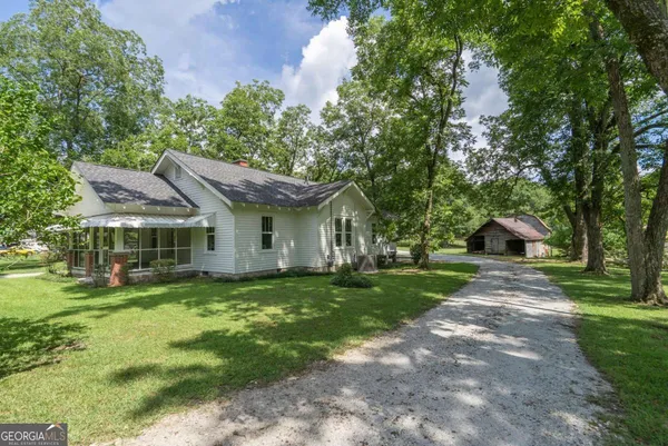 a front view of a house with a yard and trees
