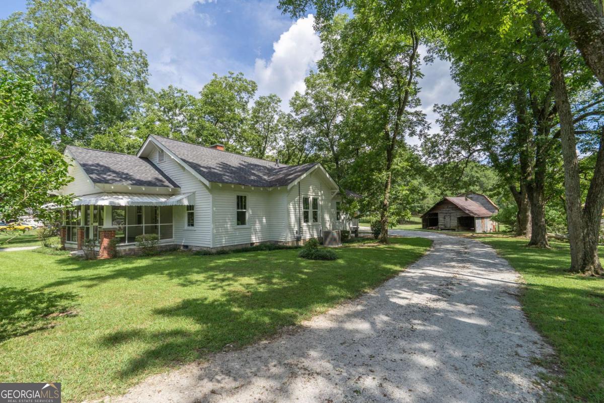 5380 Guthrie Road Loganville, GA 30052 - Photo 5 of 38 a front view of a house with a yard and trees