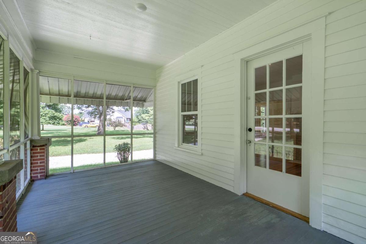 5380 Guthrie Road Loganville, GA 30052 - Photo 7 of 38 a view of an empty room with wooden floor and a window