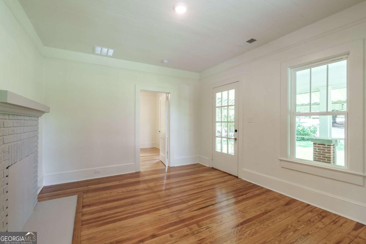 5380 Guthrie Road Loganville, GA 30052 - Photo 9 of 38 a view of an empty room with wooden floor and a window