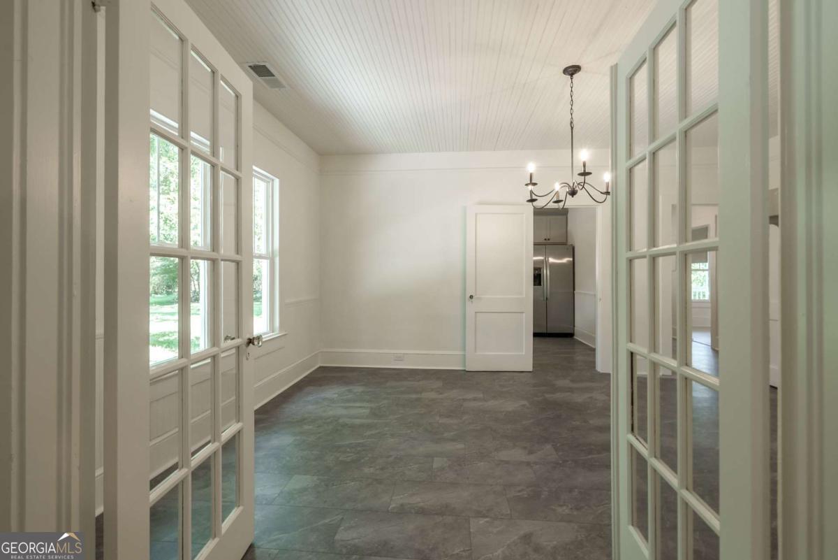 5380 Guthrie Road Loganville, GA 30052 - Photo 10 of 38 a view of an empty room with wooden floor and a window