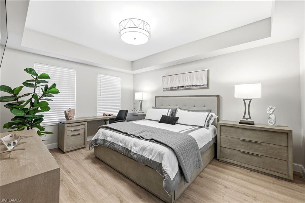 401 Bayfront Place, Unit 3307 Naples, FL 34102 - Photo 11 of 28 Bedroom featuring a tray ceiling and light wood-style flooring