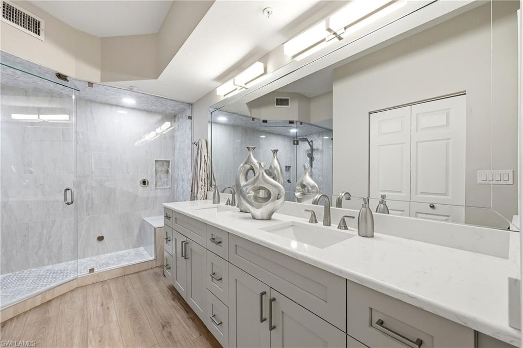 401 Bayfront Place, Unit 3307 Naples, FL 34102 - Photo 15 of 28 Full bath featuring a stall shower, double vanity, light wood-type flooring, and a closet
