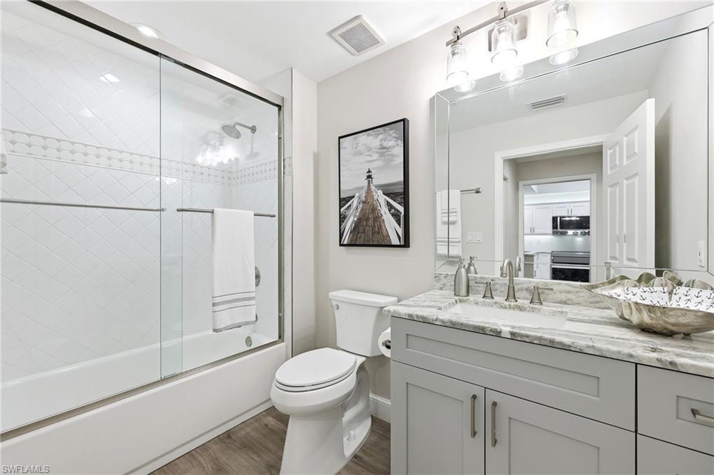 401 Bayfront Place, Unit 3307 Naples, FL 34102 - Photo 19 of 28 Bathroom featuring vanity, bath / shower combo with glass door, and dark wood finished floors