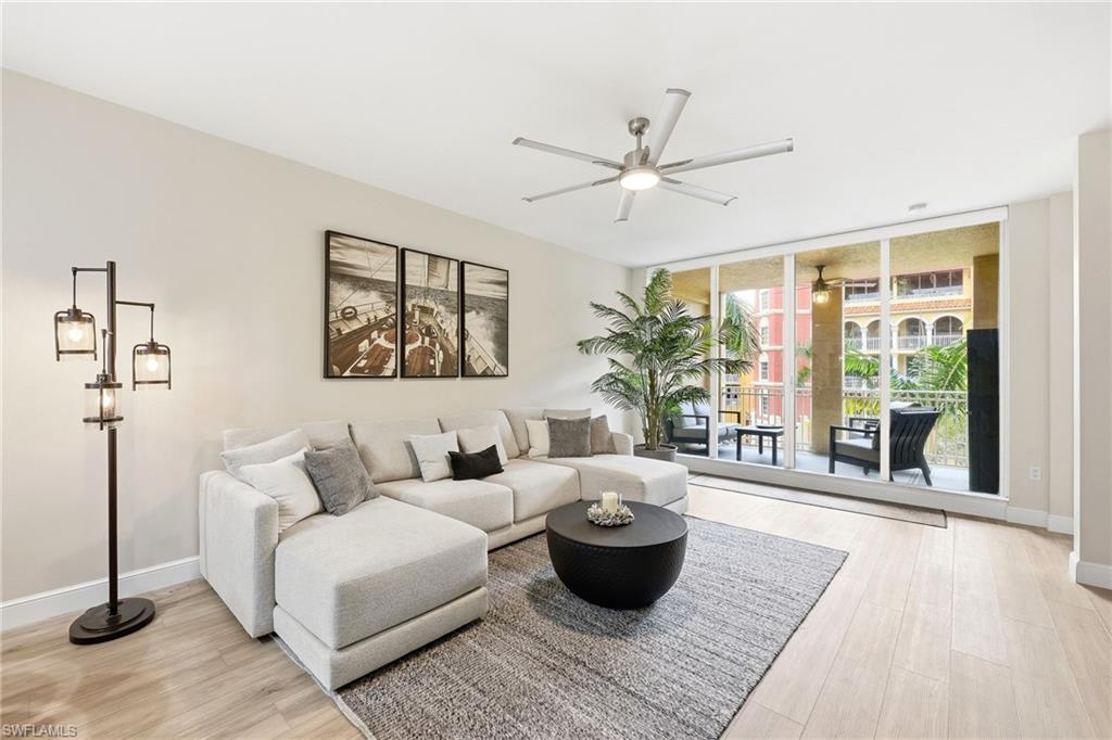401 Bayfront Place, Unit 3307 Naples, FL 34102 - Photo 2 of 28 Living area with expansive windows, light wood-style floors, and a ceiling fan