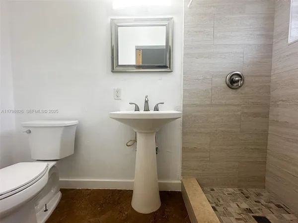 a bathroom with a sink a toilet and mirror