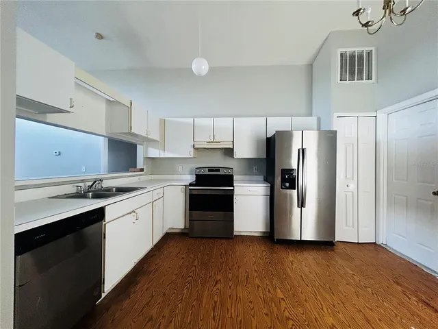 a kitchen with granite countertop a refrigerator and a stove top oven