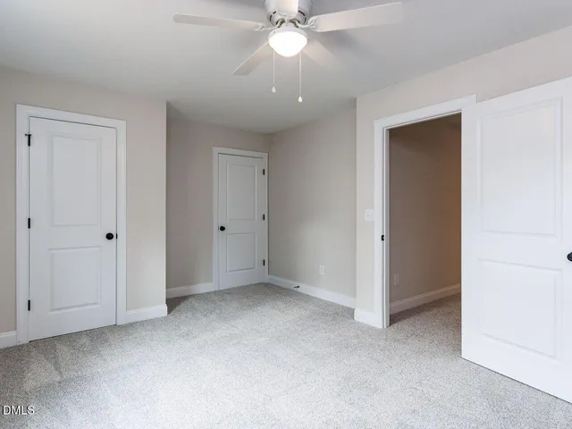 a view of an empty room with a ceiling fan