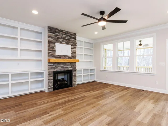 a view of an empty room with a fireplace and a window
