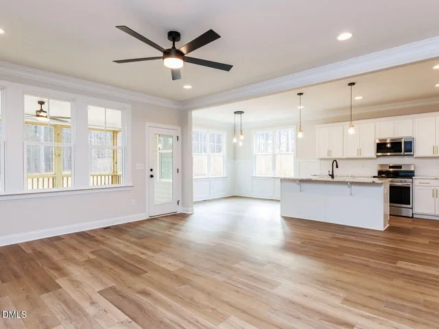 a view of an empty room with window and wooden floor