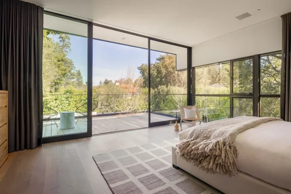 a spacious bedroom with a large window and a bed