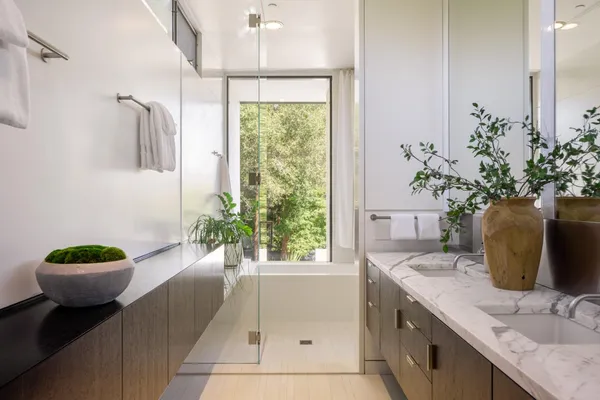 a bath room with a sink and a large mirror
