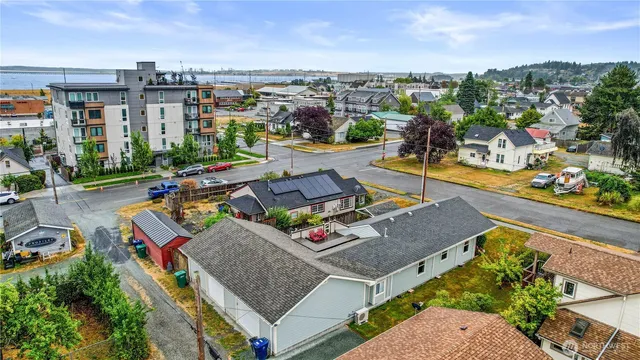 an aerial view of a house with swimming pool and large trees