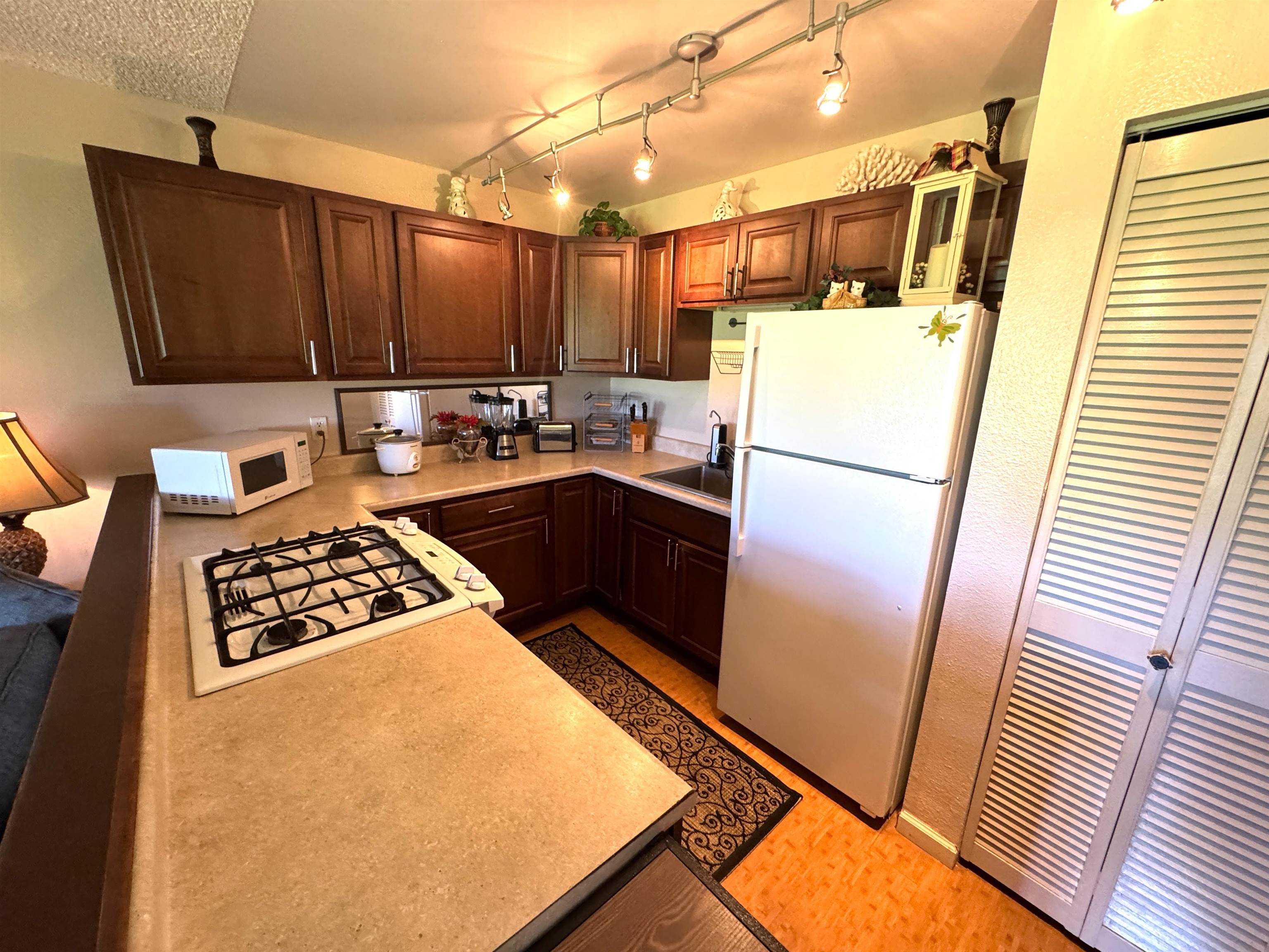 Kamehameha V Highway, Unit 123B Kaunakakai, HI 96748 - Photo 14 of 25 a kitchen with a refrigerator and a stove